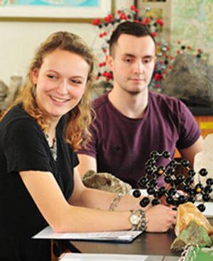 MCC geology students in classroom working with mineral samples and molecular models